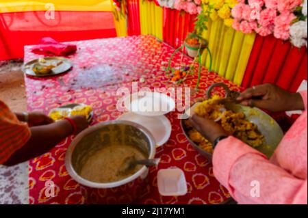 Verschwommenes Bild von Howrah, Westbengalen, Indien. VOG, prasad, oder heilig angebetet Nahrung, die an eifrige Anhänger, nach Anbetung Idol Gottes verteilt. Stockfoto