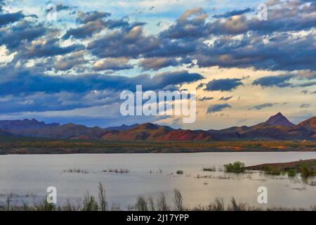 Sonnenuntergang und Wolkenlandschaft über Alamo Lake, Arizona, USA. Die Rawhide Mountains leuchten in der Abendsonne. Stockfoto