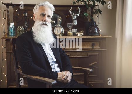 Gutaussehender bärtiger älterer Mann, der im Studio posiert Stockfoto