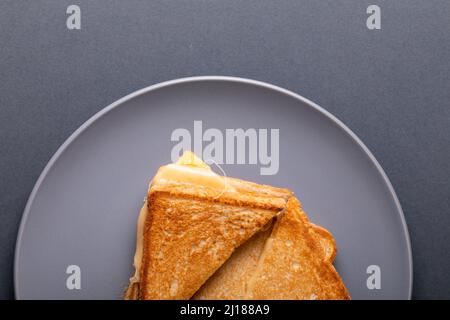 Blick von oben auf das frische Käse-Toast-Sandwich, das auf einem blauen Hintergrund serviert wird Stockfoto