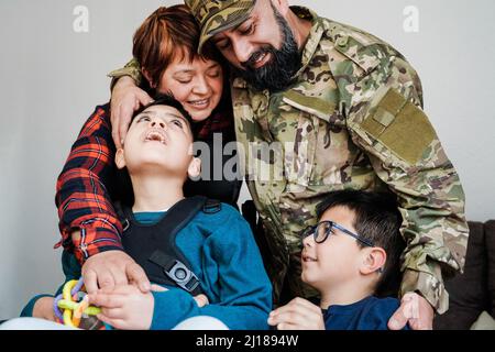 Glücklicher Militärsoldat, der nach der Heimkehr einen zarten Moment mit der Familie hat - Liebe und Kriegskonzepte - Konzentrieren Sie sich auf das Gesicht eines Veteranen Stockfoto