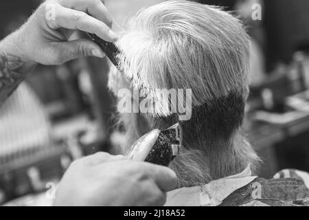 Friseur macht stilvolle Frisur für alten Mann Stockfoto