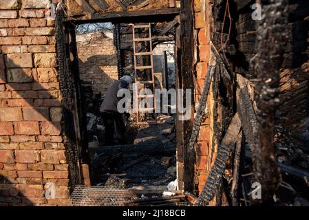 Kiew, Maine, Ukraine. 23. März 2022. Ein Anwohner putzt sein Haus, das niedergebrannt wurde, als ein Schrapnel von einem russischen Luftangriff in Kiew getroffen wurde. (Bild: © Seth Sidney Berry/ZUMA Press Wire) Stockfoto