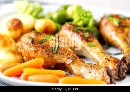 Hühnerschenkel mit Kartoffeln, Karotten, Broccoli und Rosenkohl braten Stockfoto