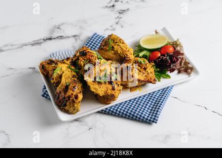 Kali Mirchi oder Schwarzer Pfeffer Rindfleisch Kebab mit Limette in einem Gericht isoliert auf Serviette Seitenansicht auf grauem Hintergrund Stockfoto