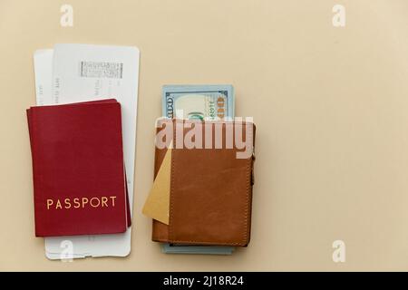 Reisepass mit Flugtickets und Geldbörsen auf beigefarbenem Hintergrund. Stockfoto