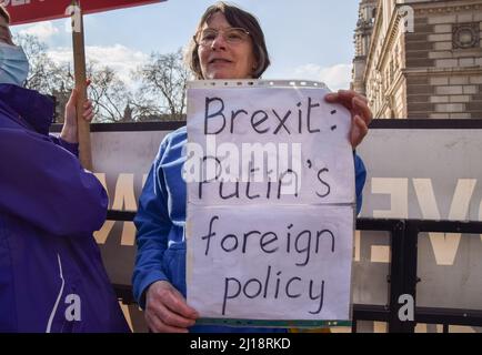 London, England, Großbritannien. 23. März 2022. Ein Protestler hält ein Schild mit der Aufschrift „Brexit: Putins Außenpolitik“. Anti-Tory-Regierung und Anti-Brexit-Demonstranten versammelten sich vor dem Parlament, als Boris Johnson den Fragen des Premierministers gegenüberstand. (Bild: © Vuk Valcic/ZUMA Press Wire) Stockfoto