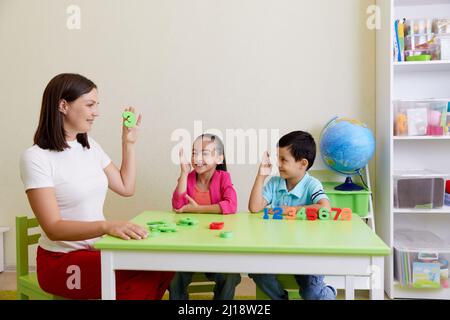 Kinder üben die korrekte Aussprache mit einem Logopädin Stockfoto