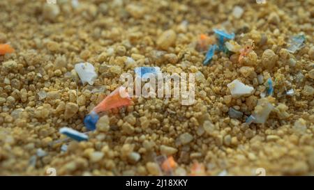 Mikroplastik im Sand am Strand. Konzept der globalen Erwärmung und des Klimawandels. Nicht recycelbare Plastikverschmutzung in den Ozeanen. Stockfoto