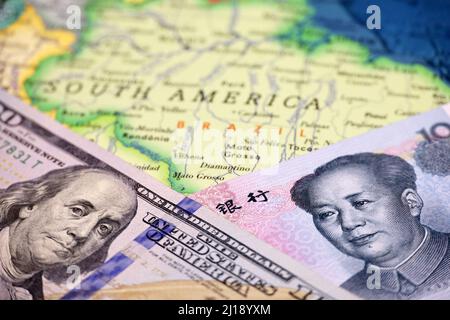 US-Dollar und chinesischer Yuan auf der Landkarte von Brasilien. Wirtschaftlicher Wettbewerb zwischen China und den USA in den Ländern Lateinamerikas Stockfoto