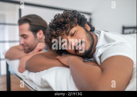 Biracial Gay paar schlafen im Schlafzimmer Stockfoto
