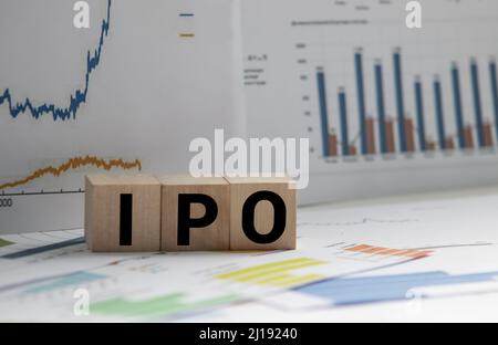 Ein Notebook mit Geschäft Anmerkungen erste Münze mit ICO vs IPO Initial Public Offering mit Office Tools auf Gelb blauen Hintergrund. Konzept der ch Stockfoto