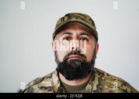 Ernsthafter männlicher Soldat beim Blick in die Kamera - Fokus auf Mütze Stockfoto