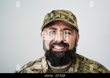 Glücklicher männlicher Soldat beim Blick in die Kamera - Fokus auf Bart Stockfoto