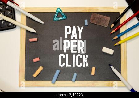 Pay-per-Click-Notiz mit Stift auf gelbem Hintergrund. Stockfoto