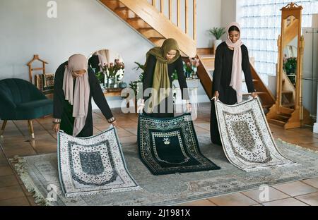 Die Vorbereitung ist wichtig. Aufnahme einer Gruppe muslimischer Frauen, die ihre Gebetsmatten zur Vorbereitung ablegten. Stockfoto
