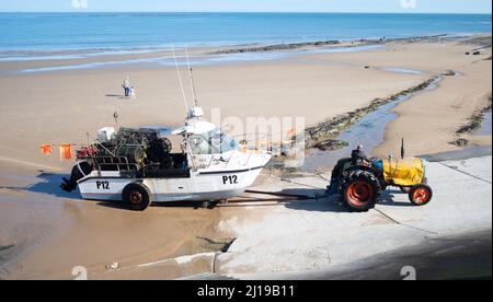 Fischer fährt einen Traktor und schleppt sein Boot P12 Kaya den Slipway vom Strand auf die Straße in Redcar Cleveland UK , Stockfoto