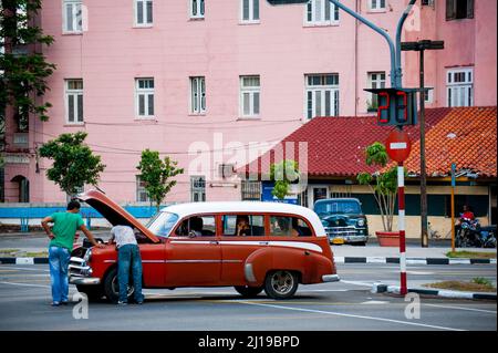 Männer reparieren ein altes kubanisches Auto an einer Straßenecke in Havanna, Kuba. Stockfoto