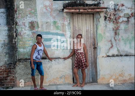 Schwuler Mann und trans-schwule Frau, die in Manzanillo, Kuba, das enge Lächeln der Frauen an der Kamera tragen. Stockfoto