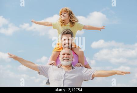 Generationenfamil. Vater, Sohn und Großvater glücklich Multi-Genration Familie mit Heben der Hände oder offene Arme fliegen am Himmel. Stockfoto