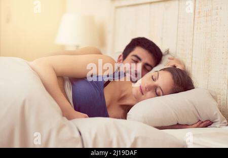 Ich schlafe besser, wenn ich neben dir bin. Aufnahme eines liebevollen jungen Paares, das zusammen im Bett schläft. Stockfoto