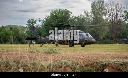 Soldaten der Alpha Company, 29. Brigade Engineer Bataillon, 3. Brigade Combat Team, 25. Infantry Division, verlassen eine US Army UH-60 Black Hawk, zugewiesen an das 2. Assault Helicopter Bataillon, 25. Aviation Regiment, 25. Infantry Division, während eines Luftangriffs, 22. März 2022, Fort Thanarat, Thailand. Luftangriffe ermöglichen es den Truppen, schnell in die Nähe eines Ziels einzugreifen und das Überraschungselement während des Angriffs zu nutzen. (USA Air Force Foto von Tech. Sgt. Michael Mason) Stockfoto