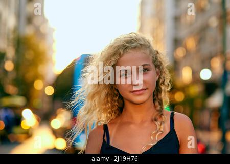 Umgeben von den Lichtern der Stadt. Beschnittenes Porträt einer attraktiven jungen Frau, die durch die Stadt läuft. Stockfoto