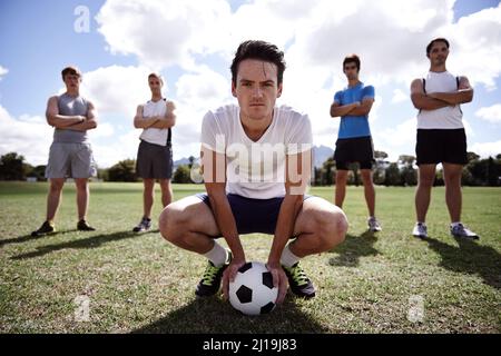 Das siegreiche Team... jedes Mal. Porträt einer Gruppe ernsthafter Fußballspieler, die auf einem Spielfeld stehen. Stockfoto