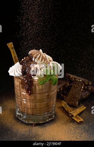 Ein Glas heiße Schokolade mit Schlagsahne und marmelow-key. Kakao Getränk mit Pulver bestreut Stockfoto