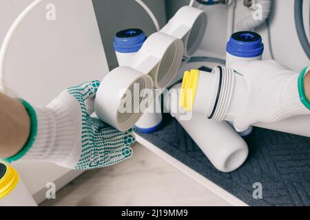 Klempner arbeiten wechseln Patronenfilter für Wasser in der weißen Küche. Konzept Filtrationssystem. Stockfoto