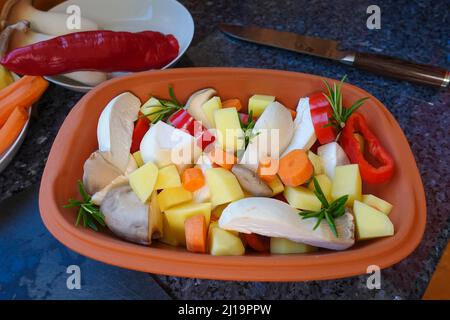 Süddeutsche Küche, Zubereitung von Gemüse aus dem Roemertopf, Gemüse aus dem Roemertopf, Pilze, Kräuterpilze, Karotten, Paprika Stockfoto