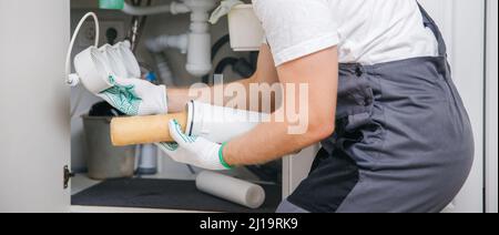 Klempner ersetzt austauschbarer verschmutzter gebrauchter Wasserfilter zur Filtration von Umkehrosmosewasser. Stockfoto