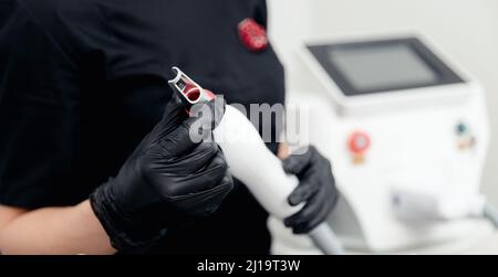 Master Hold in Hand Laser Entfernung von Permanent Make-up Tattoo im Salon. Konzept Verjüngung Verfahren Hautpflege. Stockfoto