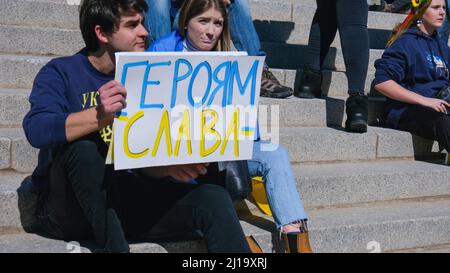 Junges Paar vor dem Kapitolgebäude bei der Ukraine-Kundgebung mit Plakat in Salt Lake City Stockfoto