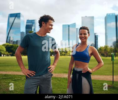 Er sucht sie nach Inspiration. Kurze Aufnahme eines liebevollen jungen, sportlichen Paares, das im Freien zusammen arbeitet. Stockfoto
