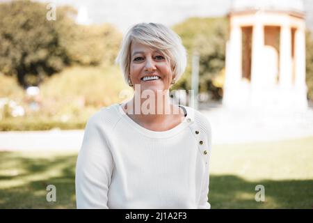 Es stellte sich heraus, dass es ein so schöner Tag war. Porträt einer reifen Frau im Freien. Stockfoto