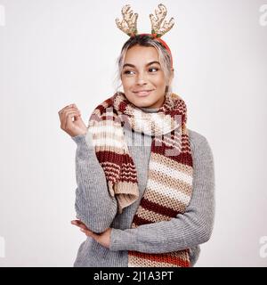 Festliche Gedanken. Studioaufnahme einer attraktiven jungen Frau, die in weihnachtlicher Kleidung nachdenklich aussieht. Stockfoto