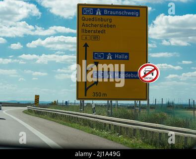 Straßenschilder auf der deutschen Autobahn, die die Straße nach Magdeburg, Halle, Quidlingburg und Braunschweig zeigen Stockfoto