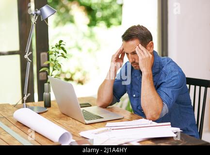 Es gibt einfach so viel zu tun Aufnahme eines Mannes, der bei der Arbeit von zu Hause aus Kopfschmerzen hatte. Stockfoto