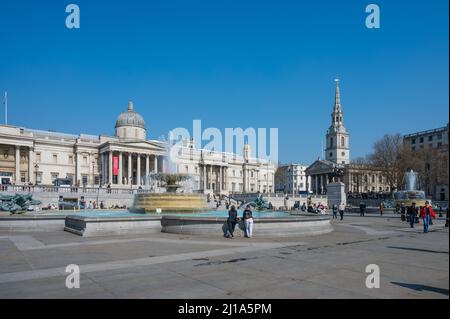 Menschen, die einen sonnigen Frühlingstag auf dem Trafalgar Square, London, England, Großbritannien, genießen möchten. Stockfoto