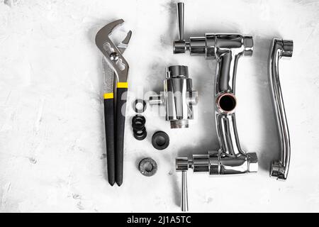 Sanitär Hintergrund - Draufsicht auf Schlüssel, zerlegtes Dusche Wasserhahn Ventil, Umleiter, Auslauf, Dichtungen auf Betonplatte mit Copyspace Stockfoto
