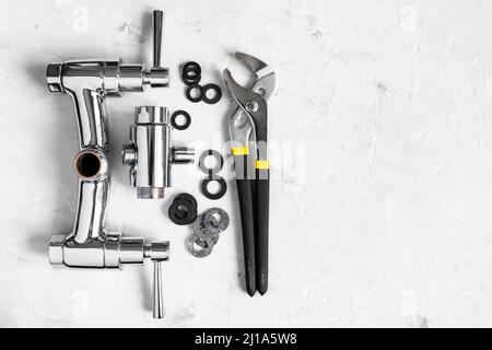 Sanitär Hintergrund - Draufsicht auf Schlüssel, Dichtungen, zerlegtes Dusche Wasserhahn Ventil, Umleiter auf Betonplatte mit Copyspace Stockfoto