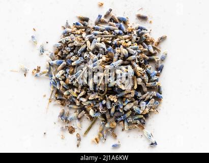 Haufen getrockneter Kräutertee aus natürlichen Lavendelblüten schließen sich auf einem grauen Teller an Stockfoto