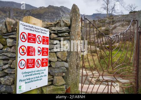 National Trust unterzeichnen durch Zugangstor zu Bergen, die die Öffentlichkeit über Naturschutzbeschränkungen informieren, Snowdonia National Park, North Wales, Großbritannien. Stockfoto