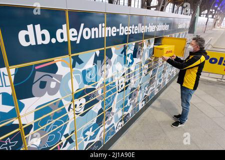 Leipzig, Deutschland. 24. März 2022. Ein Mitarbeiter der Deutschen Post arbeitet während einer Präsentation am Hauptbahnhof an einer Packstation. Deutsche Bahn und Deutsche Post starten eine Kooperation zu Packstationen. Quelle: Sebastian Willnow/dpa-Zentralbild/dpa/Alamy Live News Stockfoto