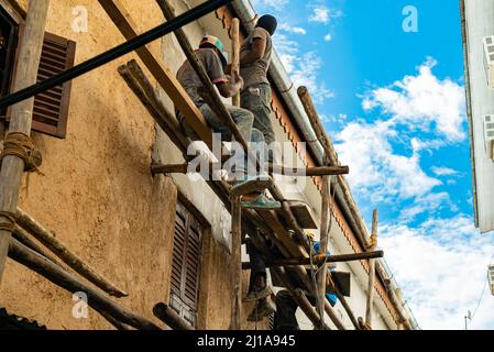 STONE TOWN, TANSANIA - 22. Dezember 2021: Arbeiter auf Gerüsten Stockfoto