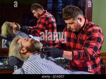 Machen Haare magisch aussehen. Männliche Schönheit und Mode. Reifer Mann im Friseursalon. Brutal bärtigen Mann beim Friseur. Friseur mit männlichen Kunden. Hipster mit Stockfoto