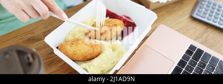 Die Angestellten aßen in der Nähe des Büros Koteletts mit Kartoffelpüree aus Pappkartons Stockfoto