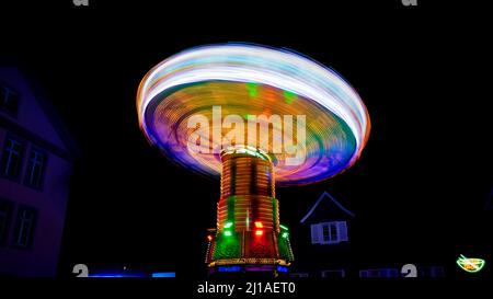 Kettenkarussell auf einem Jahrmarkt bei Nacht in Bewegung Unschärfe Stockfoto