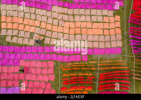 Narayanganj, Dhaka, Bangladesch. 24. März 2022. Tausende von bunten Tüchern werden zum Trocknen unter der heißen Sonne ausgelegt. Nachdem der Stoff gefärbt wurde, werden sie auf einem etwa 10.000 Quadratfuß großen Feld im Batik Village in Narayanganj, Bangladesch, verteilt.Sobald sie trocken sind - was normalerweise vier Stunden dauert - werden sie zu Kleidung gemacht, die weltweit verkauft wird. (Bild: © Mustasinur Rahman Alvi/ZUMA Press Wire) Bild: ZUMA Press, Inc./Alamy Live News Stockfoto